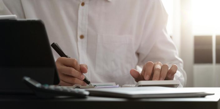 Close up of man using calculator. Serious office worker prepare financial report. Professional accountant