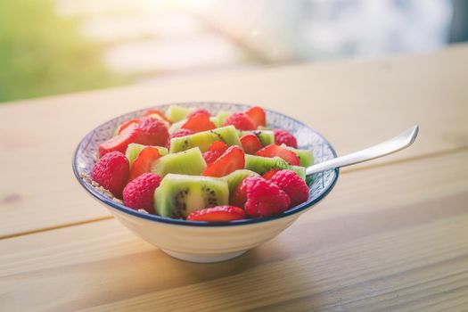 Close up of strawberries and kiwis in a ceramic bowl