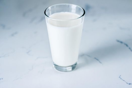 Dairy, healthy nutrition and breakfast concept - World Milk Day, full glass on marble table