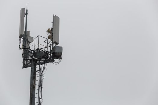 communication and gsm, wcdma, hspda and other 3g, 4g standarts tower close-up in cloudy weather.