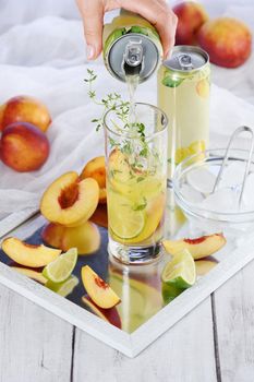 Peach summer cocktail. Refreshing organic non-alcoholic drink, lemonade with ripe nectarine, thyme and lime  