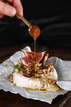 Baked camembert with nuts and honey, fig and thyme slices.