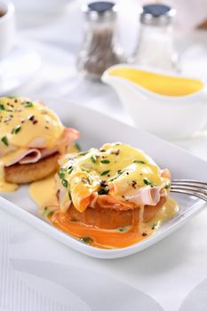 Breakfast. Best Eggs Benedict - fried English bun, ham, poached eggs and delicious Hollandaise   butter sauce