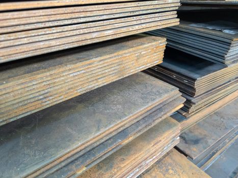 stacks of thick rusted flat metal sheets - close-up with selective focus