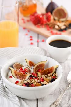 Healthy and delicious breakfast. Oatmeal muesli with Greek yogurt, fresh figs, dried fruits and pomegranate.
