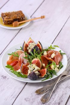 Appetizer arugula with Parma ham and fresh figs stuffed blue cheese, honey