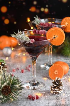 Goblet with cranberry Margarita with candied cranberries, rosemary and tangerine. Perfect cocktail for a Christmas party