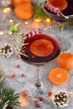 Goblet with cranberry Margarita with candied cranberries, rosemary and tangerine. Perfect cocktail for a Christmas party