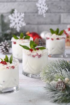 White Christmas mojito made from liqueur, tequila, coconut milk with pomegranate seeds, coconut flakes and refreshing mint.