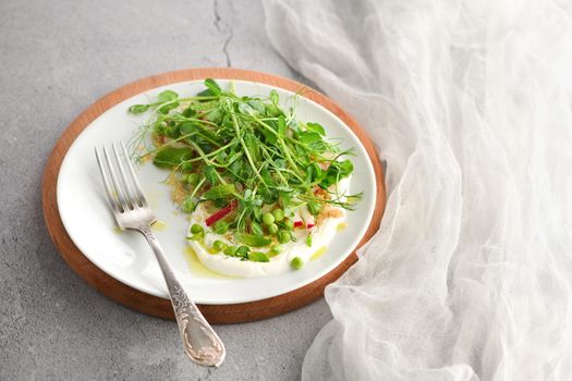 Vegan healthy salad made microgreen sprouts peas, quinoa, radish, mint and yogurt 