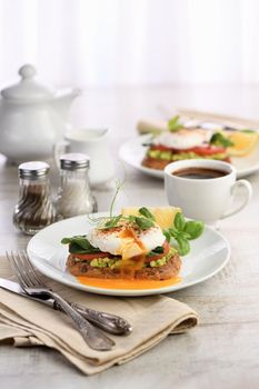  Breakfast. Best Eggs Benedict on a slice of toasted cereal bread with guacamole and spinach