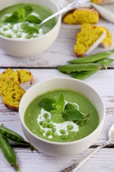 Chilled soup puree of green peas,  seasoned with green onion, mint and crunchy  toasted diced rusk bread  