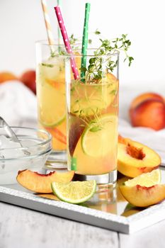 Peach summer cocktail. Refreshing organic non-alcoholic drink, lemonade with ripe nectarine, thyme and lime  