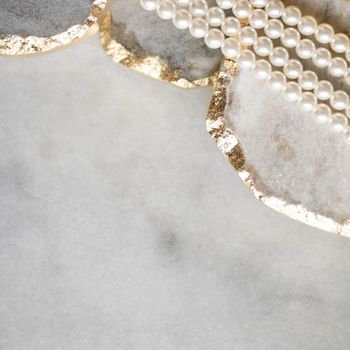 Pearl necklace on golden marble, ethical jewellery - luxury background, jewelry as a gift concept. Pearls are girl's best friends