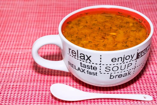 tomato soup in a mug on a red background top view. High quality photo