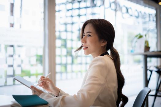 Asian Business woman checking email at morning in office. finance, fund, investment concept. soft focus