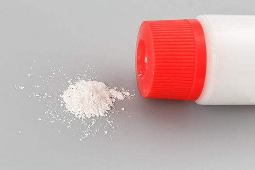 white plastic bottle of baby powder on gray background.