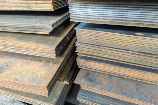 stacks of thick rusted flat metal sheets - close-up with selective focus