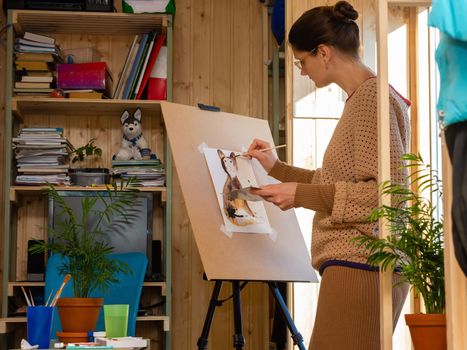 Girl artist draws on an easel at home