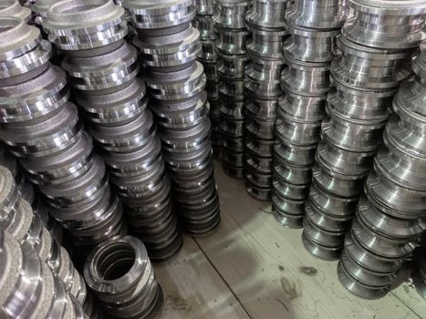 stacks of many turned forgings in wooden box.