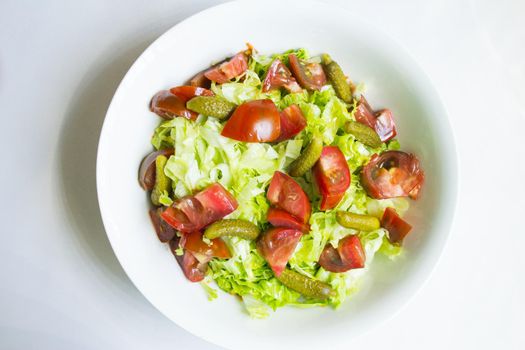 Lettuce salad with tomato and pickles. Raw food