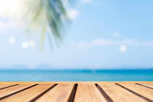 Selective focus of old wood table with blur beautiful beach for display your product.