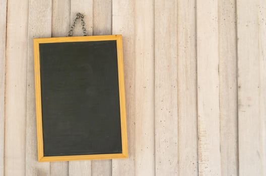 Blank copyspace black board on wooden wall background.