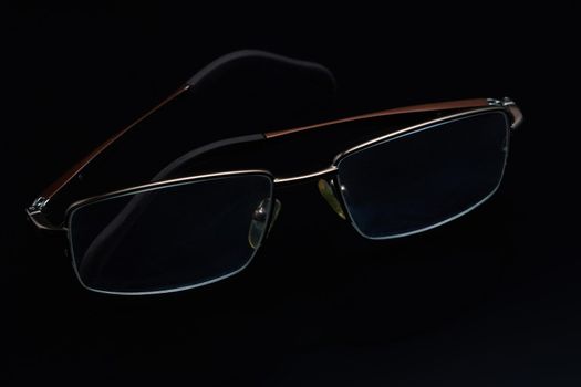 Glasses in fashionable frames on a black background. Close up