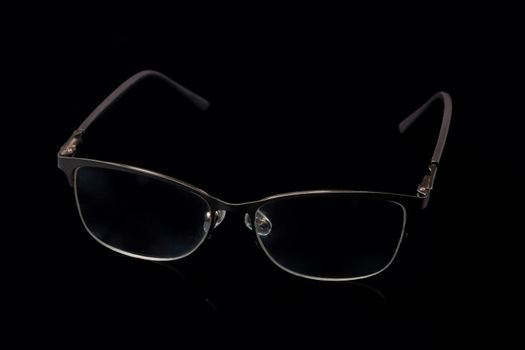 Glasses in fashionable frames on a black background. Close up