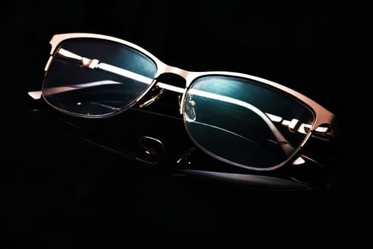 Glasses in fashionable frames on a black background. Close up