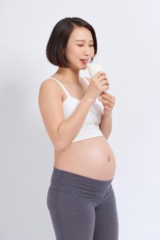 Pregnant woman holding glass of milk in her hand good healty, isolated on white background.