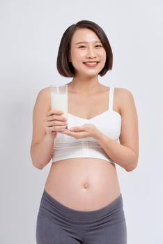 Pregnant woman drinking milk on the white background.