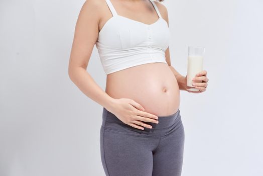 pregnant girl drinks milk on a white background