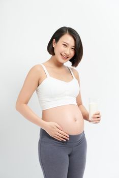 Pregnant woman drinking milk on the white background.