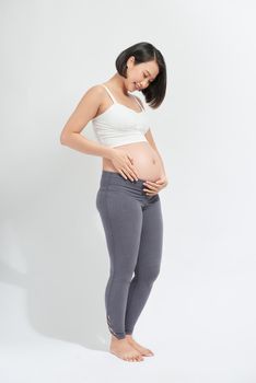 pregnant woman caressing her belly over white background