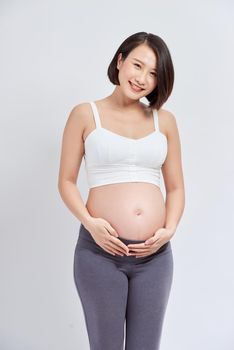 Beautiful asian pregnant woman expecting baby and touching her belly