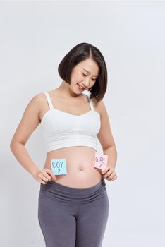 Pregnant woman with a sticky note and writing love boy or girl on sticky note and add on her belly,P
