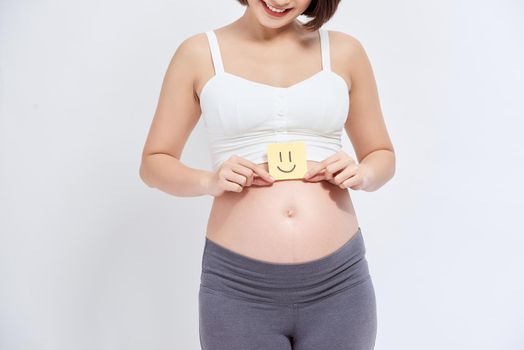Asian pregnant woman with sticky note on her belly