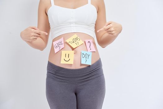 Pregnant woman with stick notes on her belly