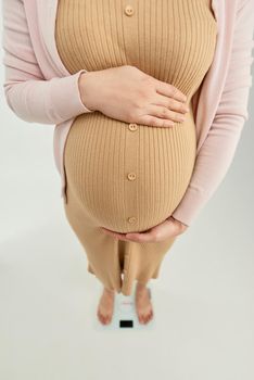 Pregnant woman standing on the scales - view from the top on the scales.