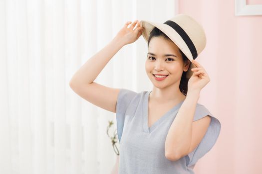 tourism, people and luggage concept - happy young woman packing travel bag at home