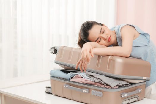 Woman prepare travel suitcase at home. Excited woman trying to close full suitcase.