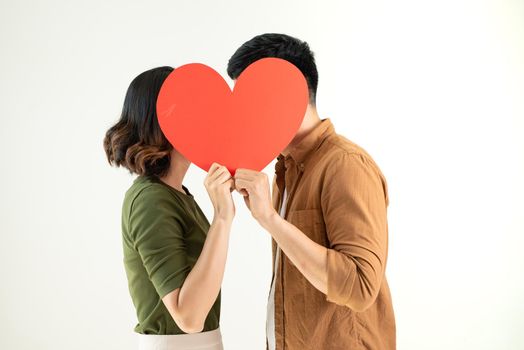 Couple kissing behind heart symbol isolated on white background