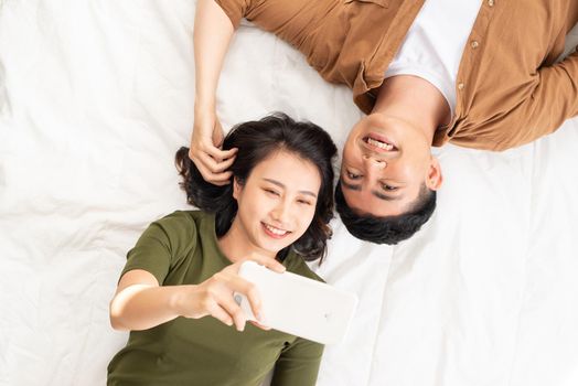 Young couple taking a selfie in their bedroom