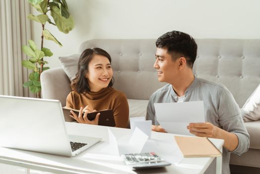 Happy couple with laptop spending time together at home