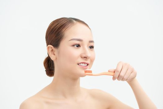 Young woman at home brushing teeth in the morning