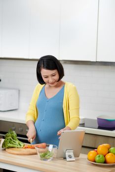 Beautiful young woman cooking in kitchen