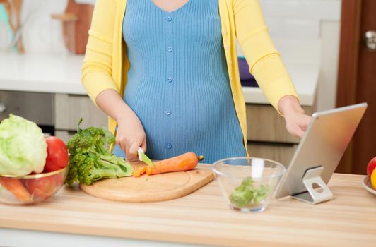 Pregnant woman eating healthy preparing meal from fresh ingredients