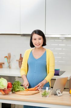 Pregnant woman preparing healthy food with fruit and vegetables. Close-up