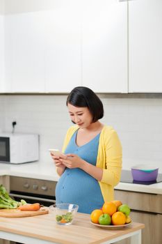 happy pregnant woman using voice command recorder on smartphone 